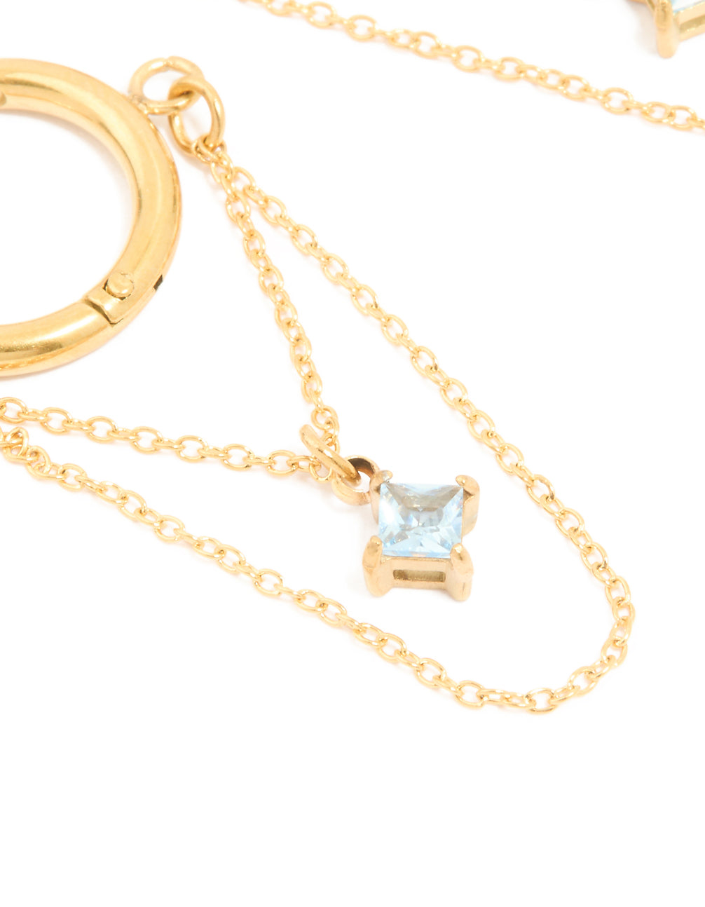 Featuring waterproof gold plated stainless steel construction, these huggie earrings and cubic zirconia detailing, huggie closure in light blue close up view