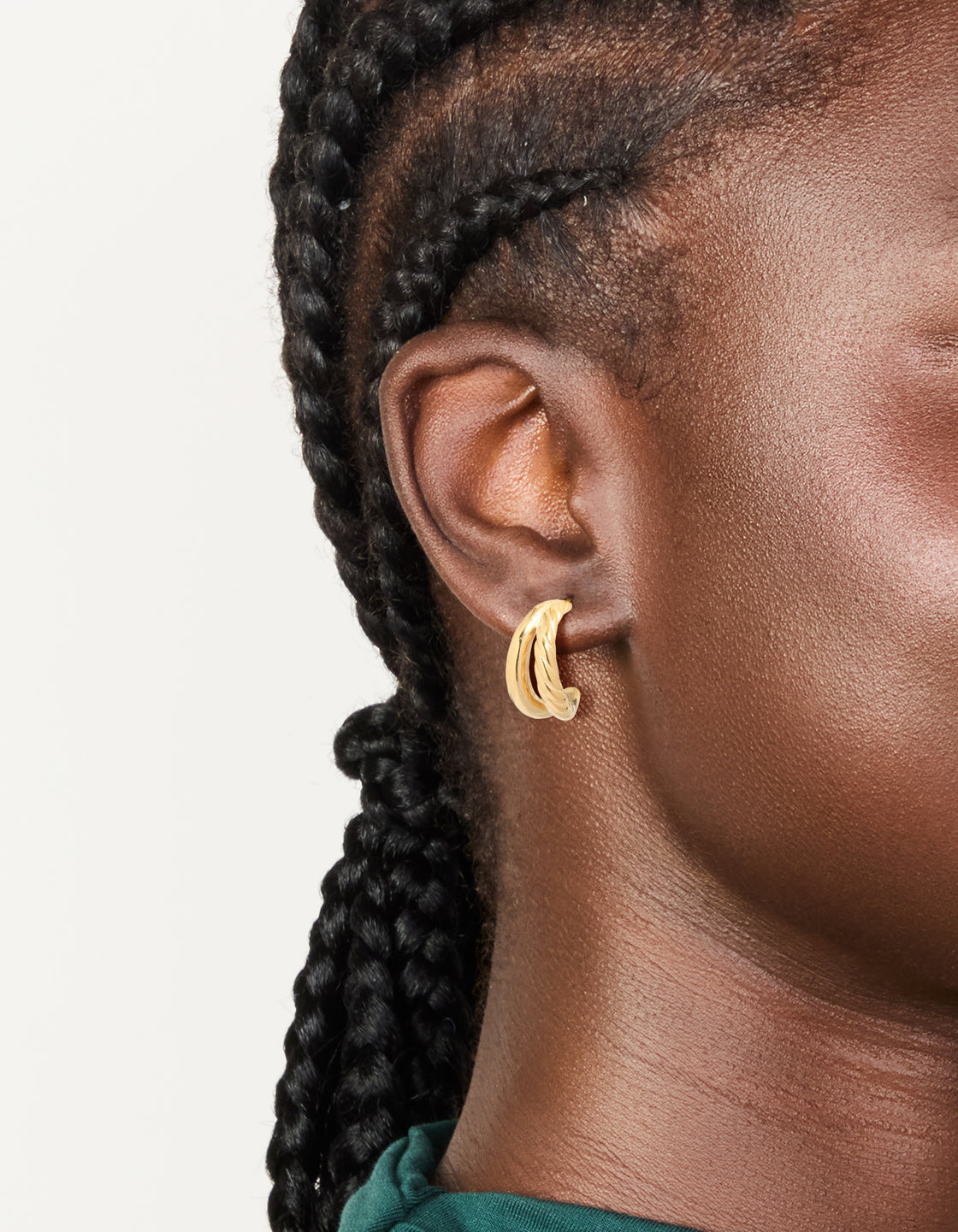 Showcasing waterproof gold plated stainless steel ribbed illusion hoop earrings in gold on ear view