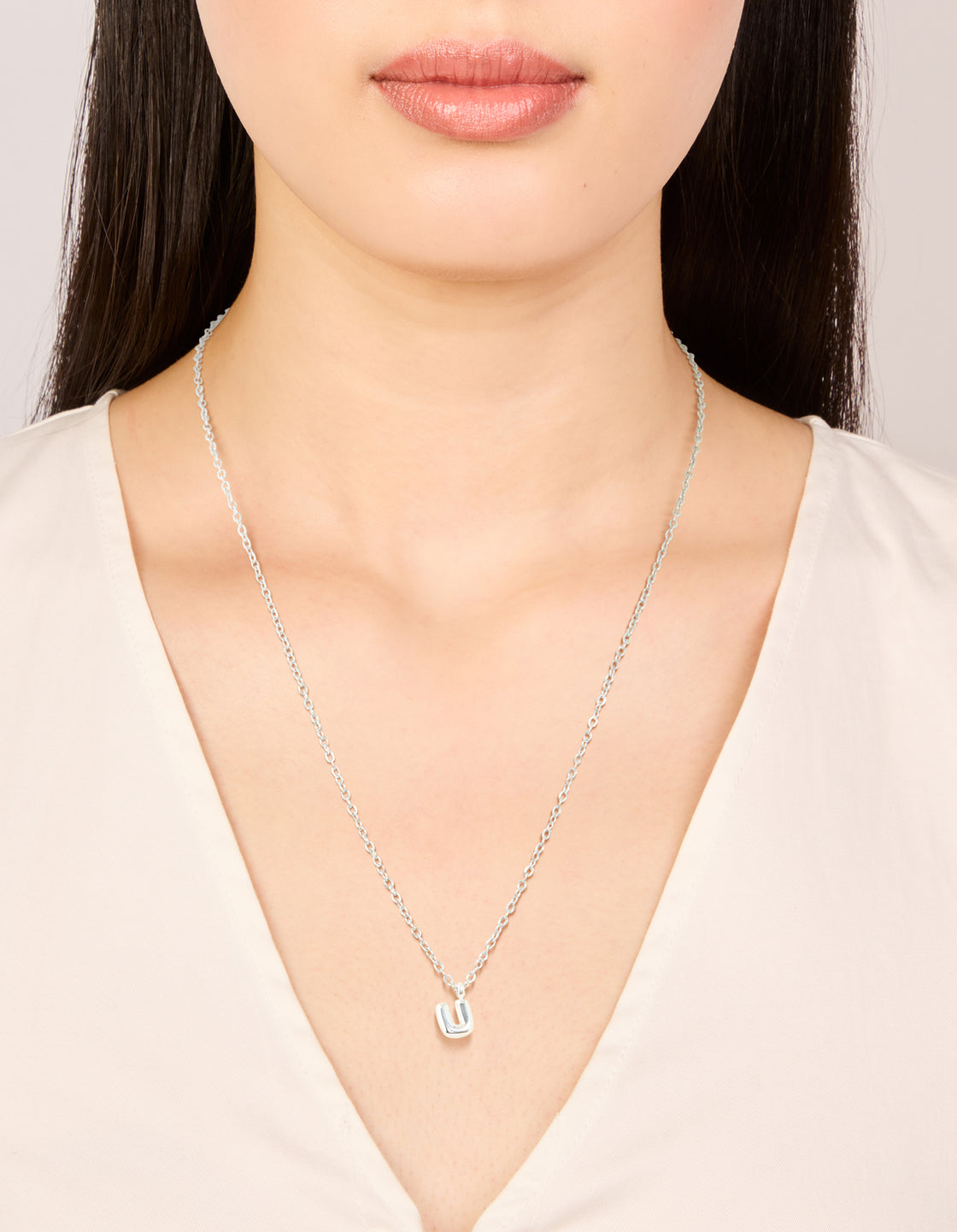 Elegant waterproof stainless steel mini bubble letter U necklace with initial pendant in silver on neck view
