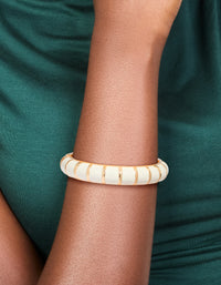 Showcasing a striped enamel bangle in gold and ivory, designed as a comfortable accessory on wrist view - link has visual effect only