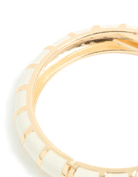 Designed with striped enamel in gold and ivory, this bangle showcases its curved structure close up view - link has visual effect only