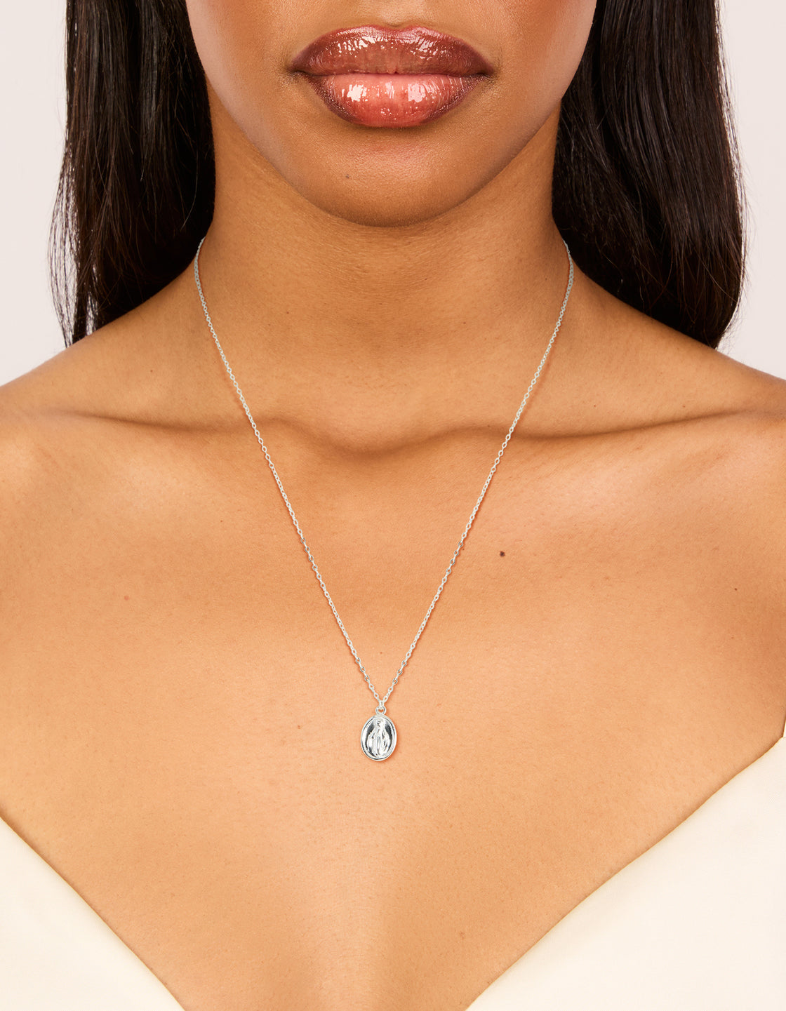 Elegantly designed sterling silver round Mary pendant necklace with statement styling in silver on neck view