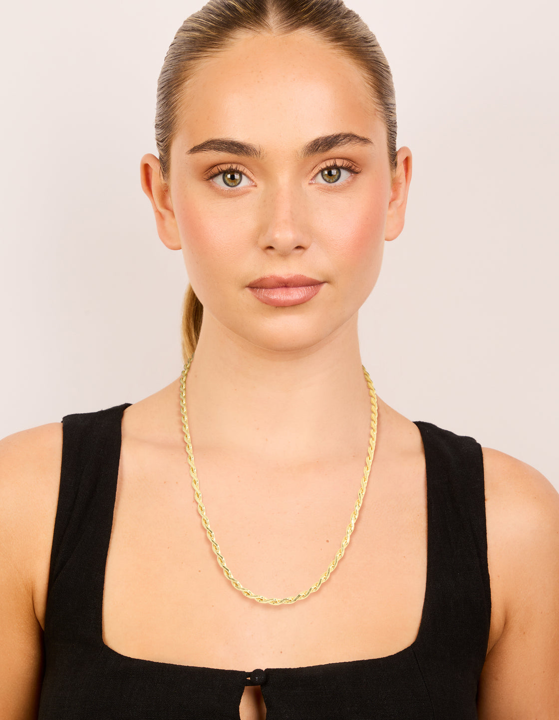 Featuring a waterproof teardrop chain link necklace made from gold plated stainless steel on model view