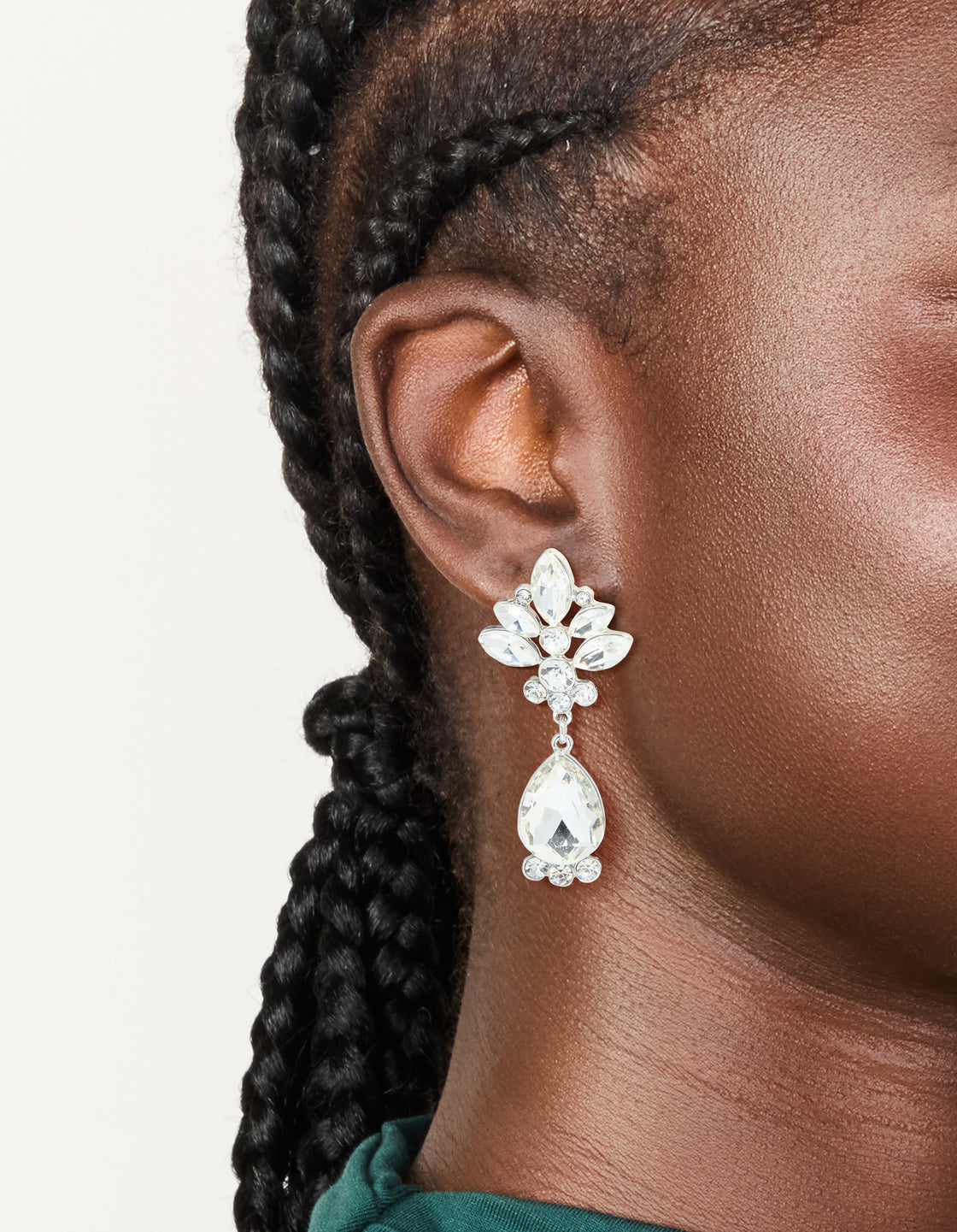 Showcasing silver diamante floral and single drop earrings with white accents side