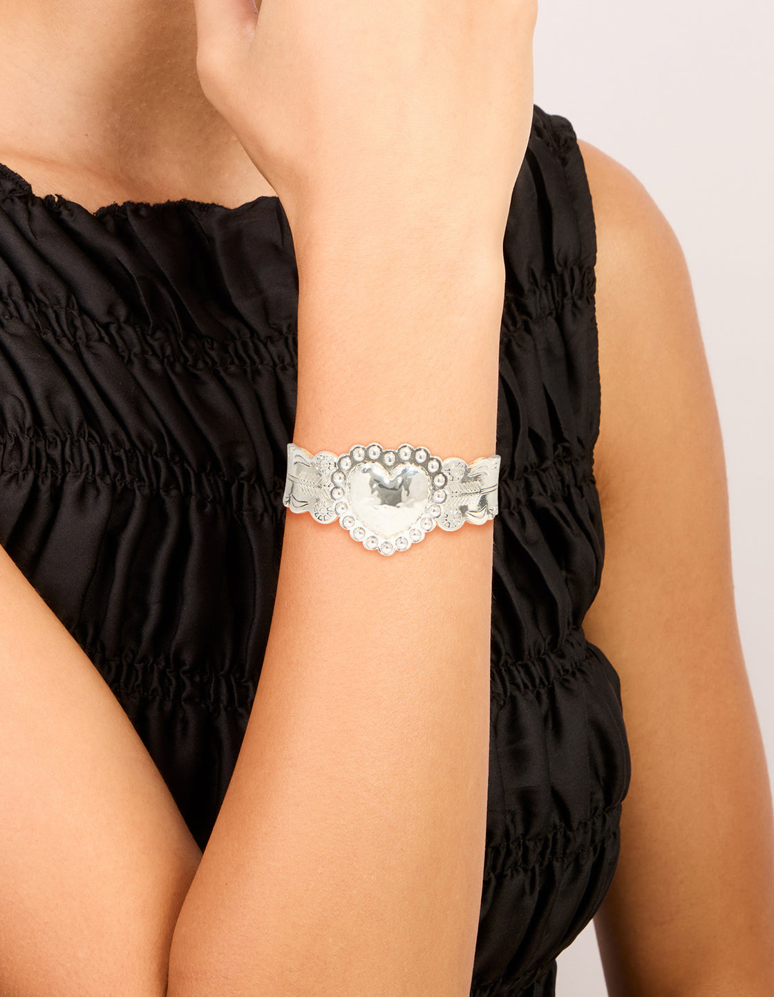 Showcasing a silver boho heart wrist cuff featuring floral details and statement styling on wrist view