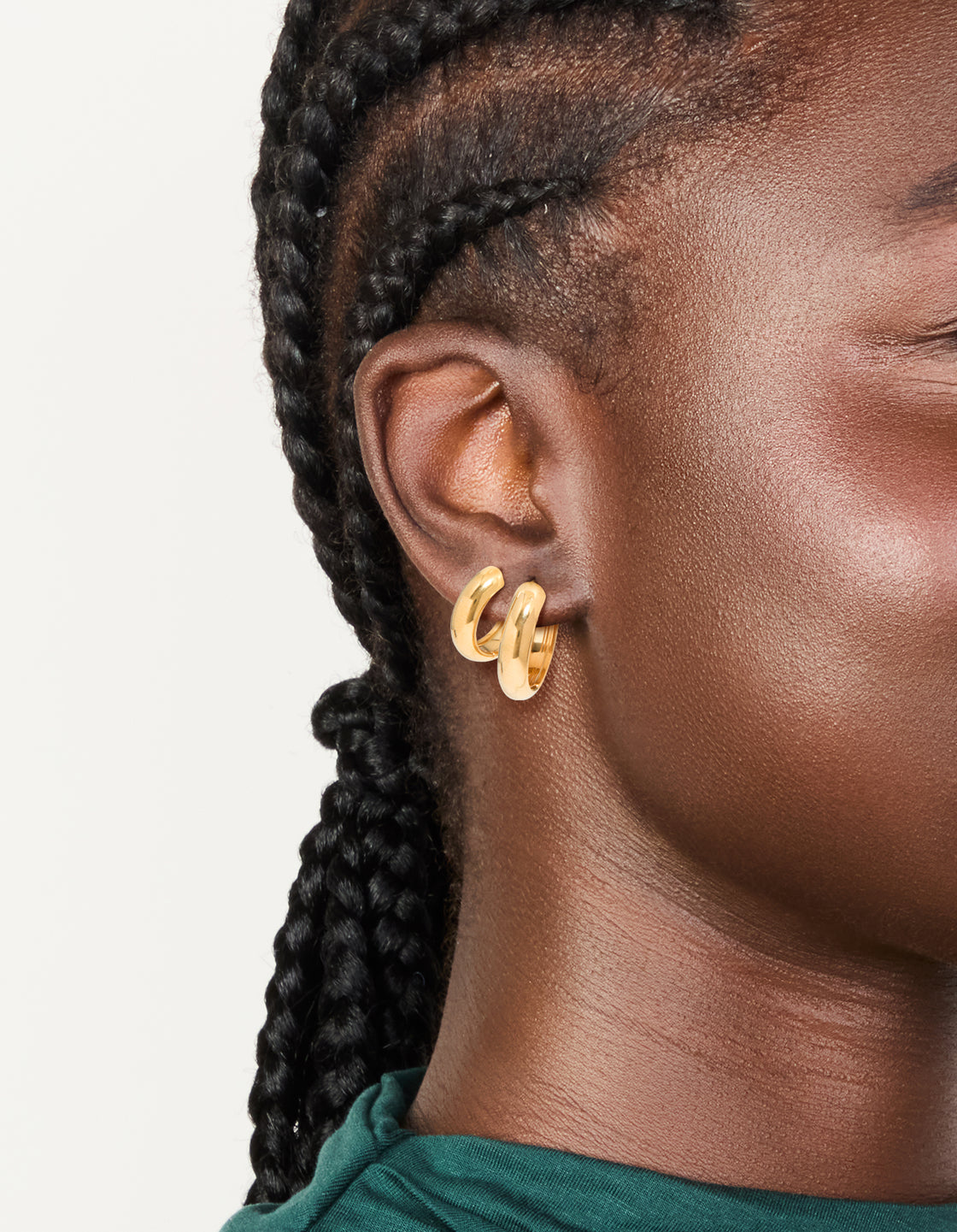 Showcasing these waterproof gold plated stainless steel thick huggie earrings in a 2-pack with chunky styling on ear view