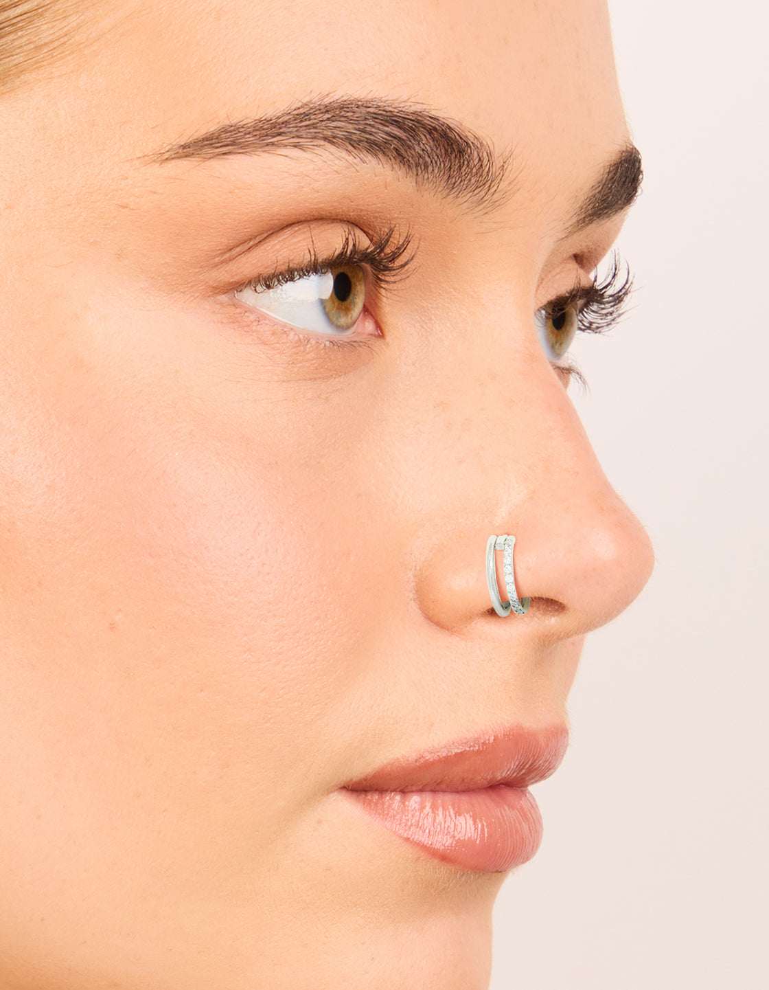 Showcasing surgical steel cubic zirconia hinged and simple nose rings in a 2-pack with diamond accents and statement style nose view
