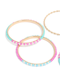 Vibrant beaded bangle set featuring gold, pink and blue accents in close up view - link has visual effect only