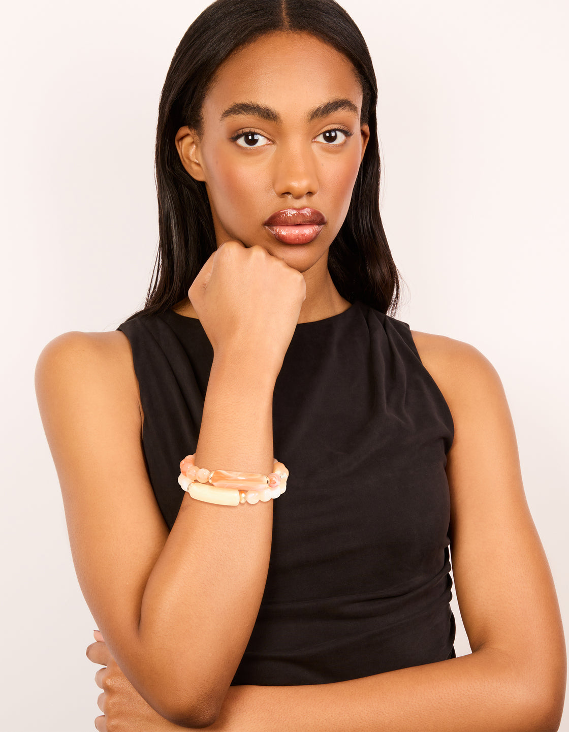 Styled pink and cream beaded stretch bracelets in a 2-pack with gold details on model view