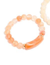 Highlighting pink and cream beaded stretch bracelets in a 2-pack with gold details in close up view - link has visual effect only