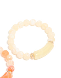Highlighting pink and cream beaded stretch bracelets in a 2-pack with gold details in close up view - link has visual effect only