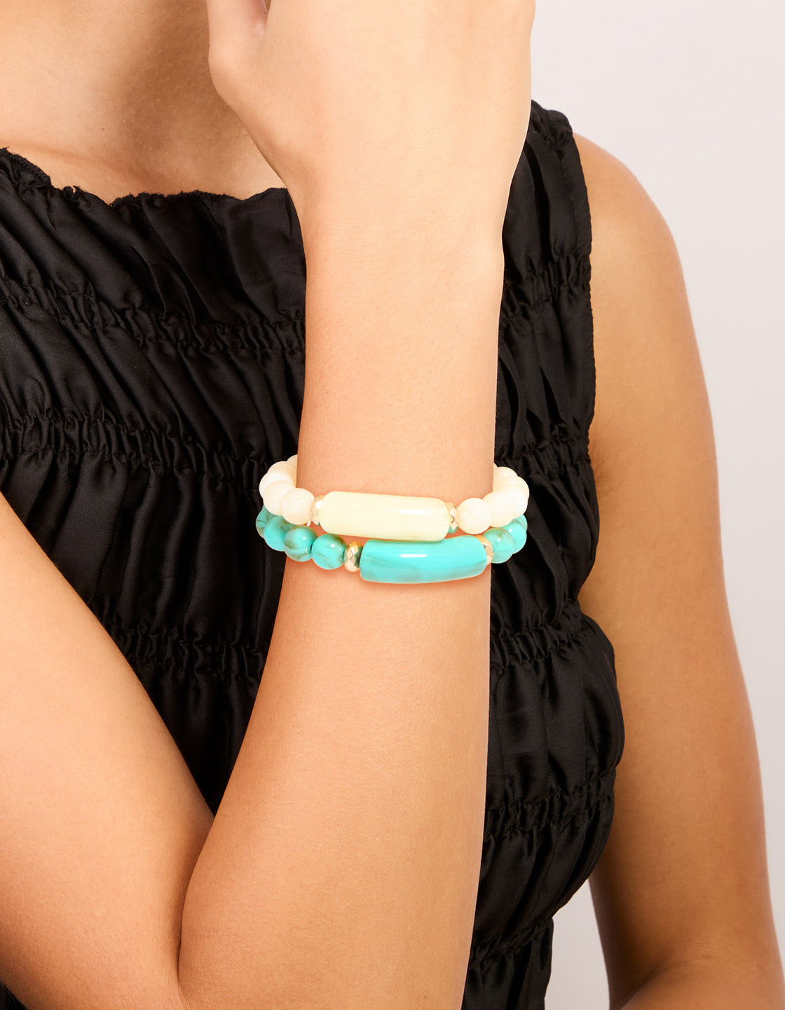 Experience this turquoise and neutral beaded stretch bracelet 2-pack featuring gold accents on wrist view