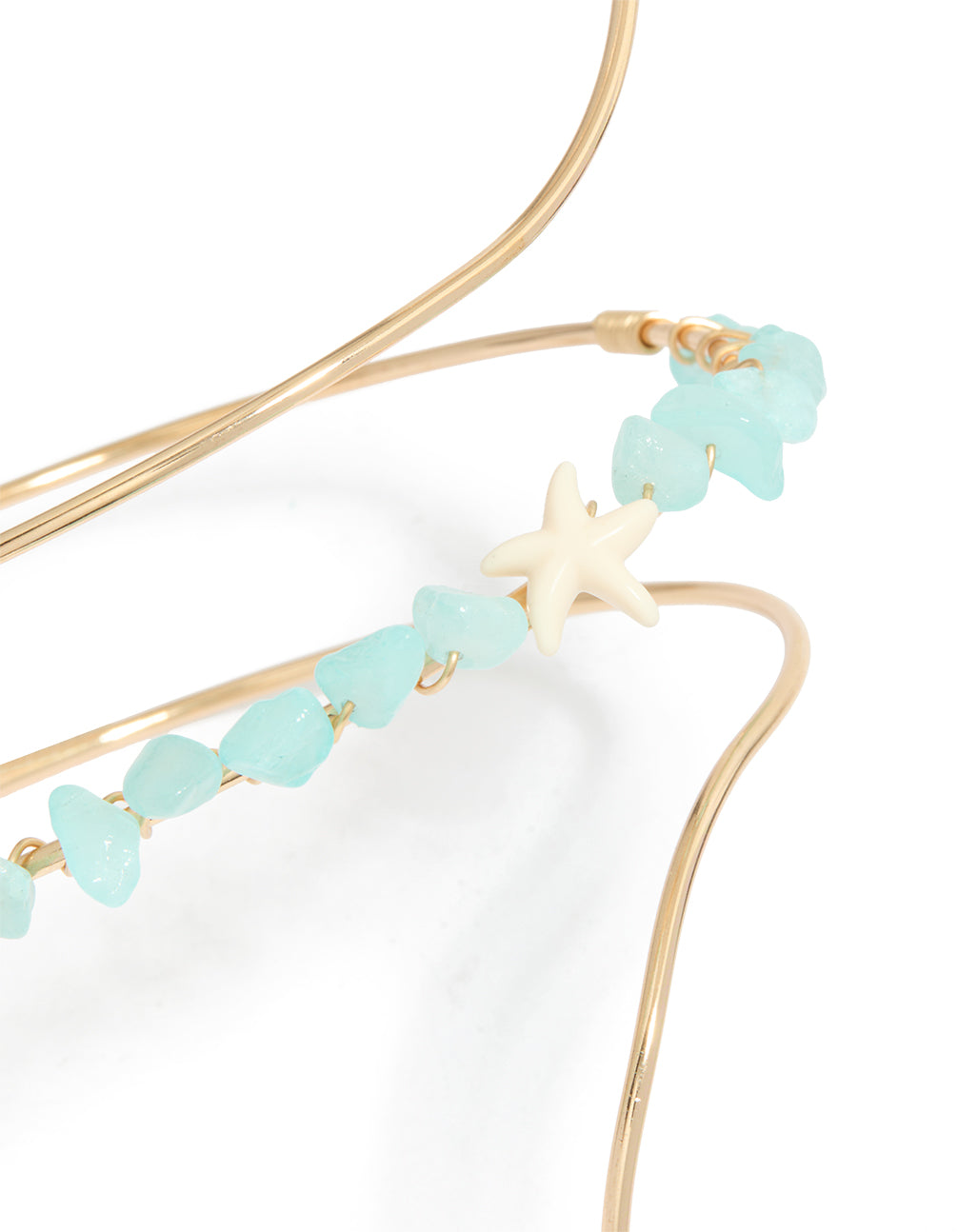 Featuring a gold turquoise semi precious stones arm cuff with beads and ocean-inspired starfish in statement style in close up view