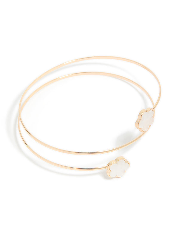 Showcasing a gold small flower arm cuff featuring floral accents in white in front view