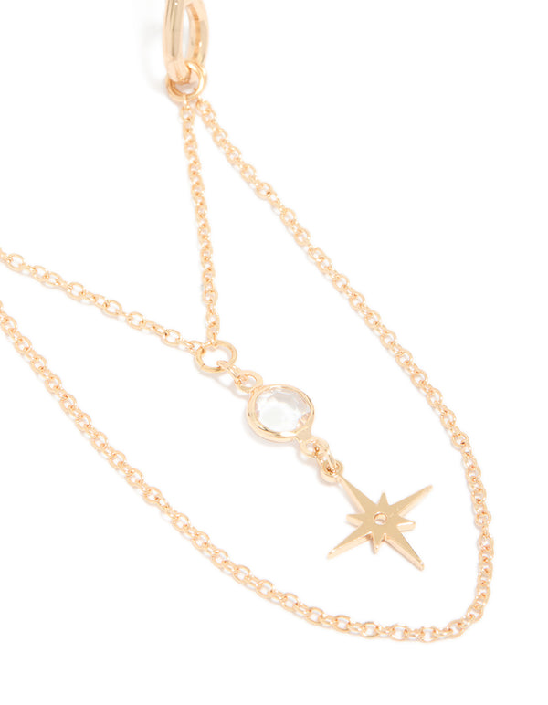 Featuring a gold celestial arm cuff with chain drop detail close up view