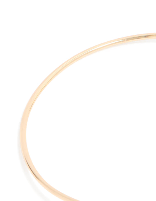 Featuring a gold celestial arm cuff with chain drop detail close up view