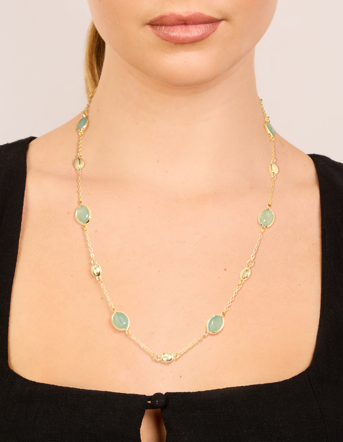 Showcasing a gold plated necklace with oval stone cut pendant in statement style on neck view
