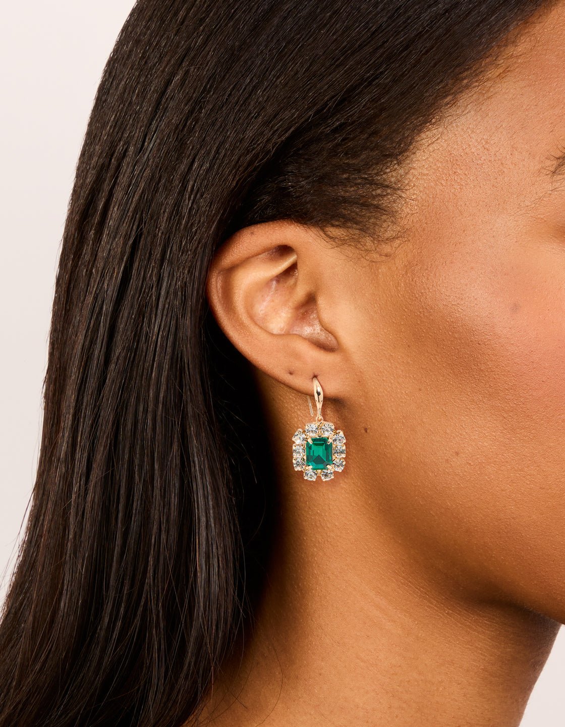 Showcasing gold pink and green diamante dainty huggie earrings in a 2-pack with clear accents on ear view