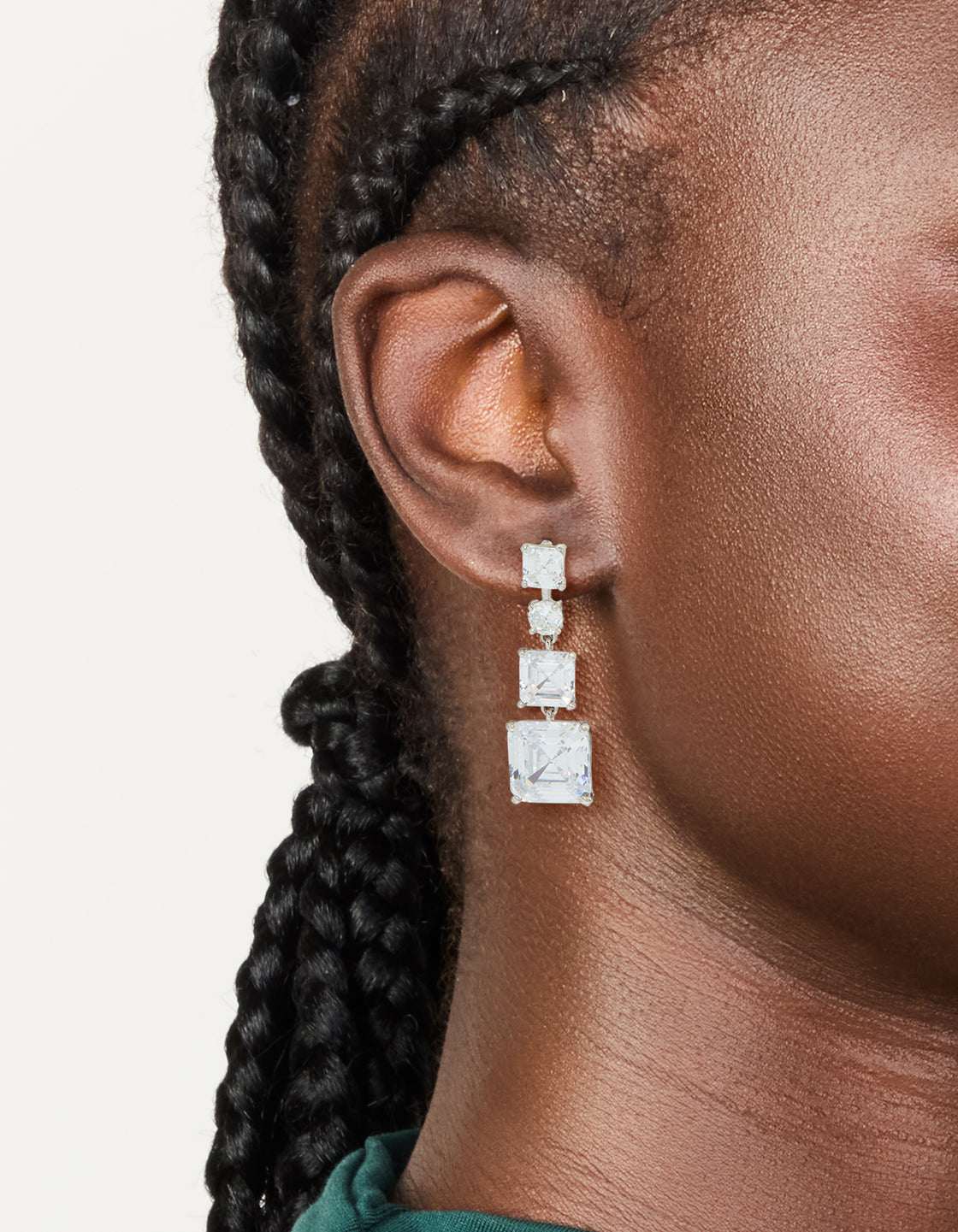 Showcasing silver cubic zirconia square drop earrings worn on ear view