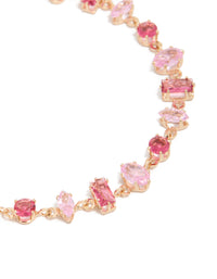 Delicate bracelet with light pink and hot pink cubic zirconia in a dainty gold design close up view - link has visual effect only