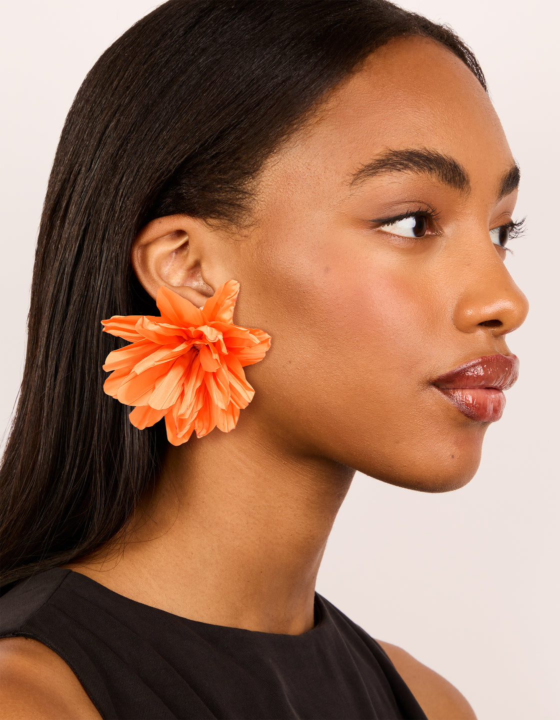 Featuring orange paper flower petal earrings with statement floral pattern on model view