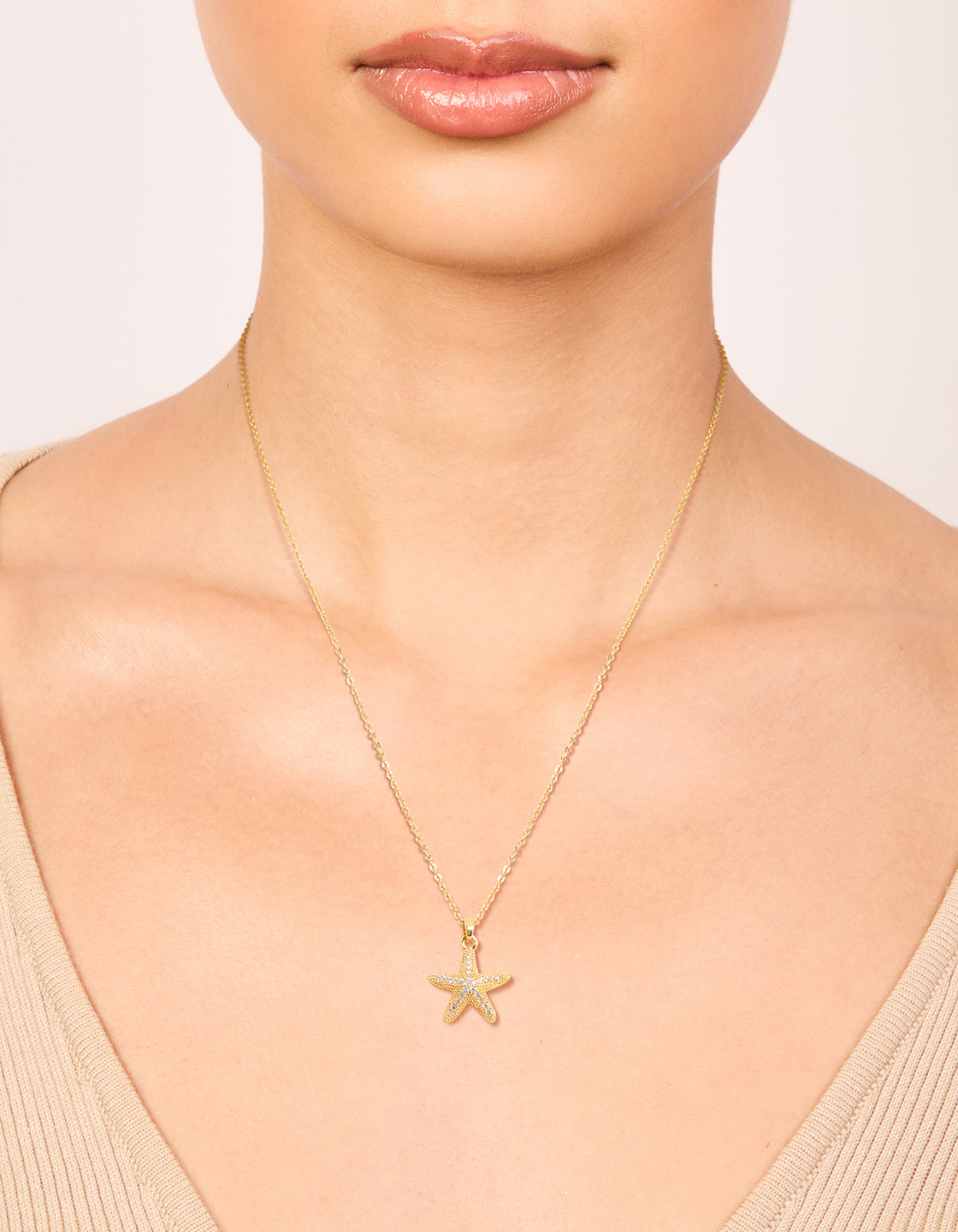 Elegantly crafted gold plated brass pavé cubic zirconia starfish pendant necklace with ocean featuring on neck view