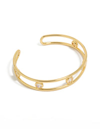 Crafted from gold plated brass, this statement bangle features bezel set cubic zirconia stones in a wrist cuff design front view - link has visual effect only