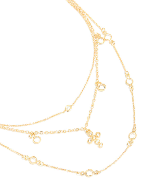 Beautifully crafted gold plated layered necklace featuring cubic zirconia bezel settings and cross pendant in statement design close up view