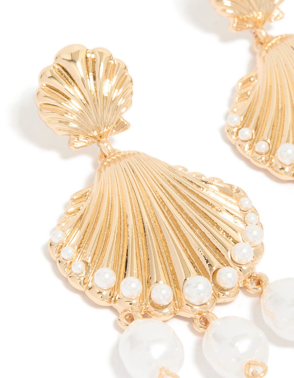 Detailed gold ribbed shell and pearls charm drop earrings with ocean theme in statement style close up view