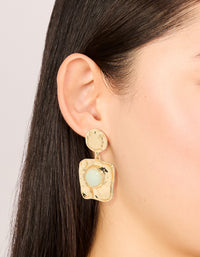 Showcasing statement drop earrings in gold with pale green stone featuring molten square design on ear view - link has visual effect only