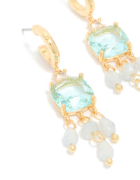 Highlighting gold plated blue cubic zirconia square drop earrings with stone and bead details, accented with charms in a statement style, close up view - link has visual effect only