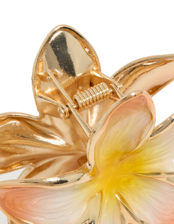 Highlighting the floral enamel peach and yellow frangipani claw clip in gold detail view