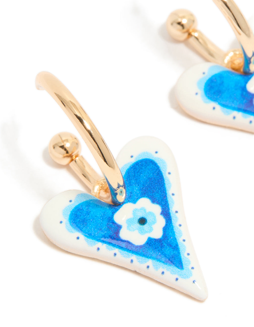 Designed with gold blue heart huggie earrings featuring a flower inside and floral pattern close up view
