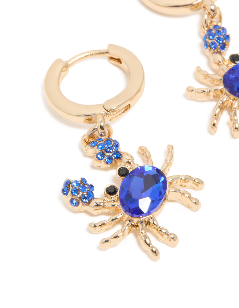 Showcasing gold dark blue diamante crab earrings with huggie closure and ocean inspired design close up view