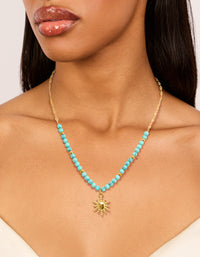 Crafted from waterproof gold plated stainless steel, this turquoise semi precious stone sunburst pendant necklace features beads and a celestial in gold on neck view - link has visual effect only