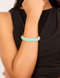 Featuring this waterproof ribbed blue enamel bangle crafted from stainless steel with gold plating on wrist view - link has visual effect only