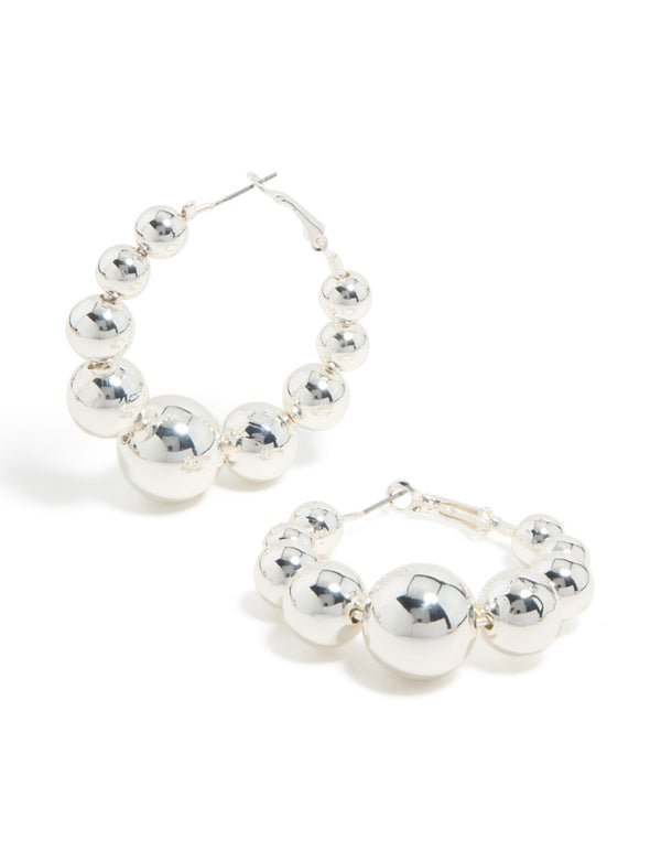 Discover these statement hoop earrings featuring balls in silver front view