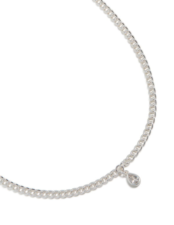 Showcasing a silver pear diamante drop Cuban link necklace with statement styling close up view
