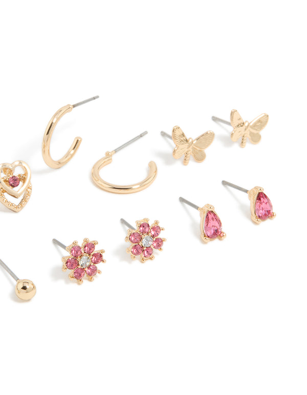 Crafted from gold with hot pink diamante, this stud earrings 7-pack showcases balls, floral, butterfly, and heart designs post detail view