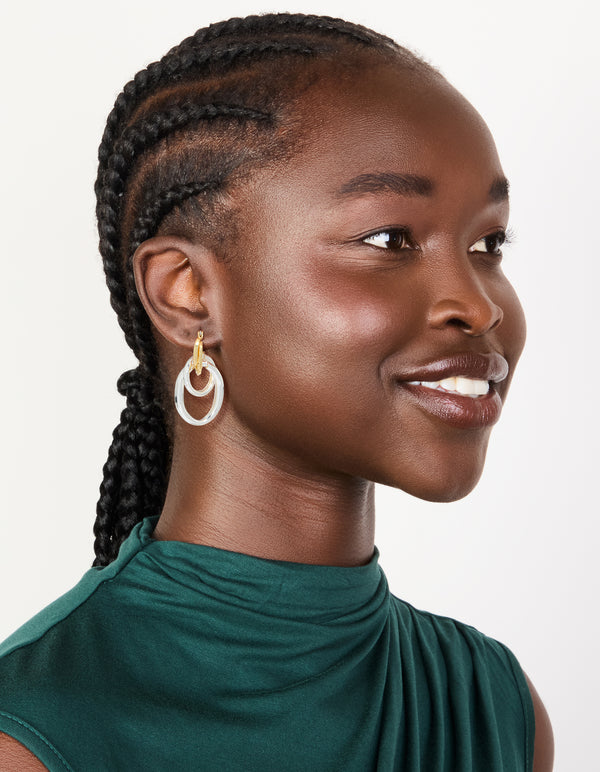 Featuring mixed metal plated double link illusion hoop earrings in gold and silver with statement style on model view