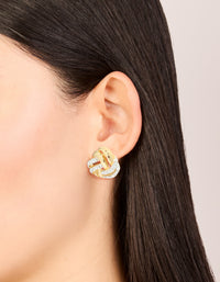 These mixed metal plated diamante knot stud earrings in gold, silver and clear stone are shown on ear view - link has visual effect only
