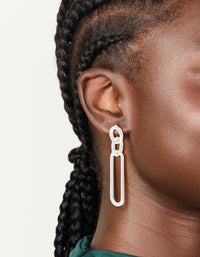Showcasing large statement drop earrings with oval link design in silver plated material on ear view - link has visual effect only