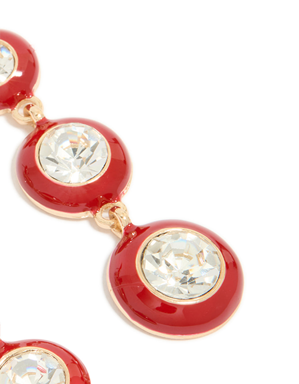 Detailed view of statement drop earrings featuring clear diamante stones set within red enamel circles and gold finish post detail view