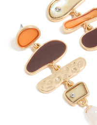 Featuring gold genuine shell and pearl mismatched drop earrings with charm ocean details close up view - link has visual effect only