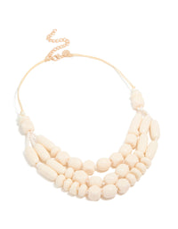Discover a beaded acrylic yarn necklace in cream and gold tones front view - link has visual effect only