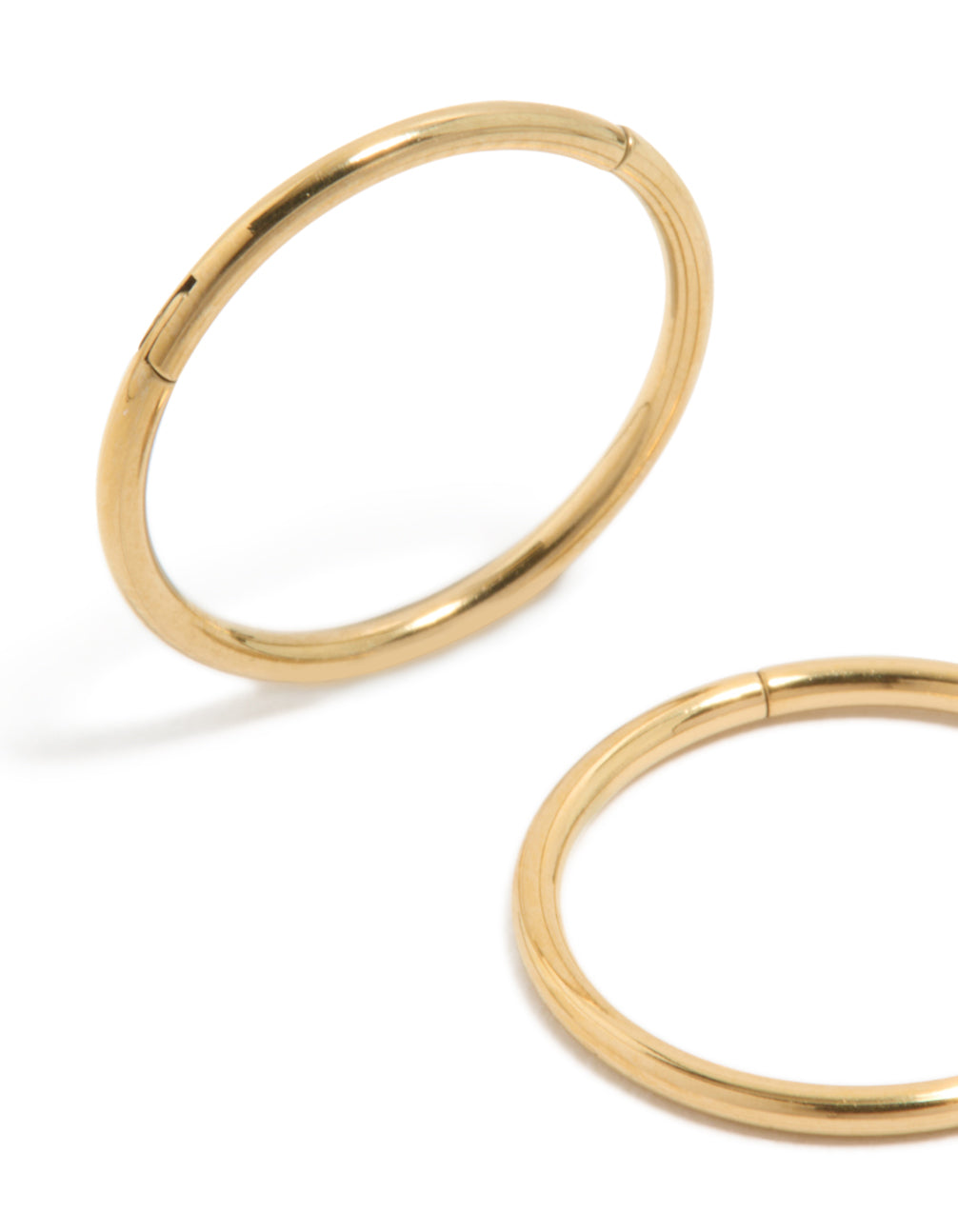 Featuring gold plated surgical steel thick sleeper earrings in 12 MM with hoop closure close up view