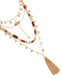 Discover a statement necklace with beads, tassel, charm and disc pendant in gold close up view - link has visual effect only