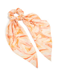 Featuring an abstract print in peachpuff, darkorange, this orange marbled fabric scarf scrunchie adds a statement touch front view - link has visual effect only