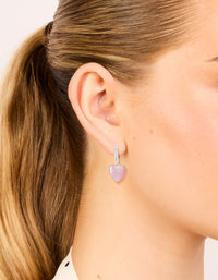 Discover dainty hoop earrings with heart drop, crafted from silver plated cubic zirconia in light pink on ear view - link has visual effect only