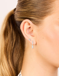 Crafted from silver plated metal, these dainty leaf studs and baguette huggie earrings with cubic zirconia in a 2-pack on ear view - link has visual effect only
